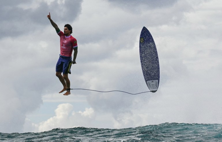 Surfer jumps off the wave after ride.