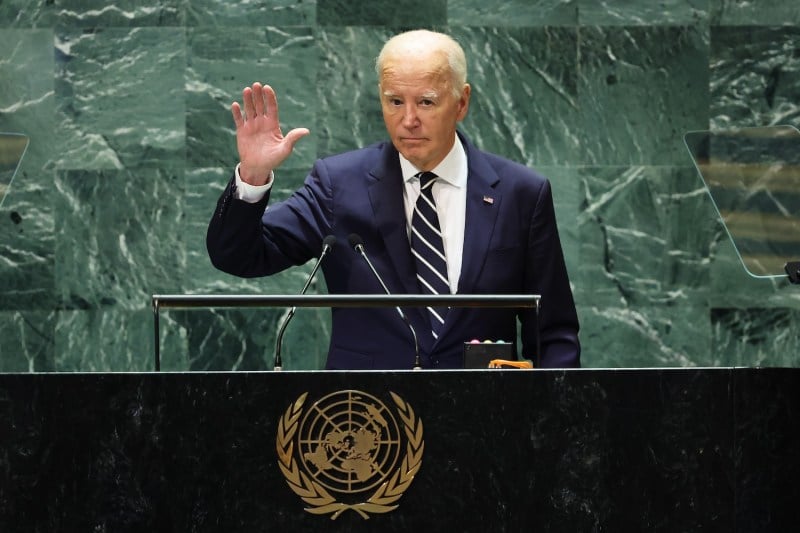 U.S. President Joe Biden waves from a podium.