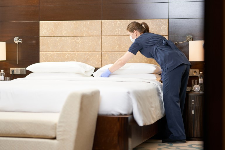 Femme de ménage nettoyant une chambre d'hôtel