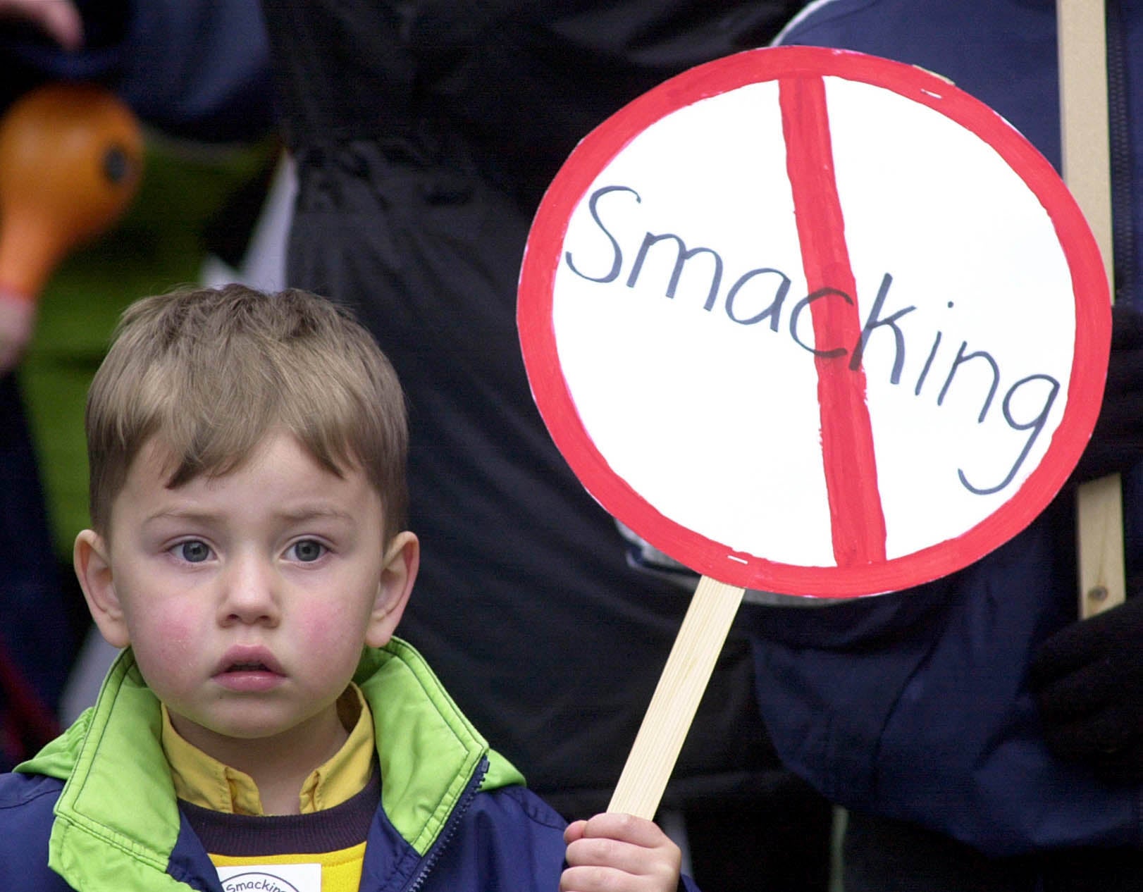 Un jeune enfant tient une pancarte contre les fessées lors d'une manifestation sur ce sujet controversé