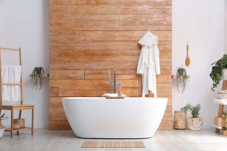 Baignoire blanche et belles plantes dans la salle de bain, design intérieur