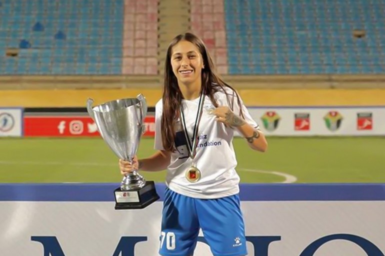 Seline Haidar célébrant avec une coupe de tournoi après un match de football en Jordanie.