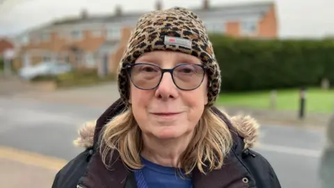 Ann Nevison devant des maisons.