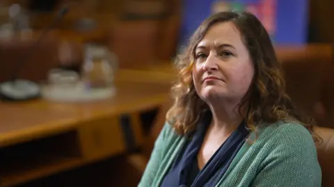 Claire Healy de l'Office des Nations Unies contre la drogue et le crime, assise dans un bureau.