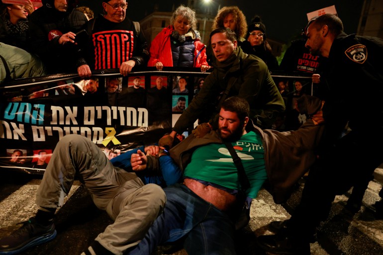 Police officers drag demonstrators as people block a road during a protest in support of the hostages kidnapped during the deadly October 7, 2023 attack by Hamas.