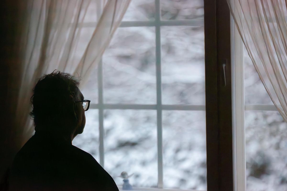 Senior man sitting alone at home. Daytime.