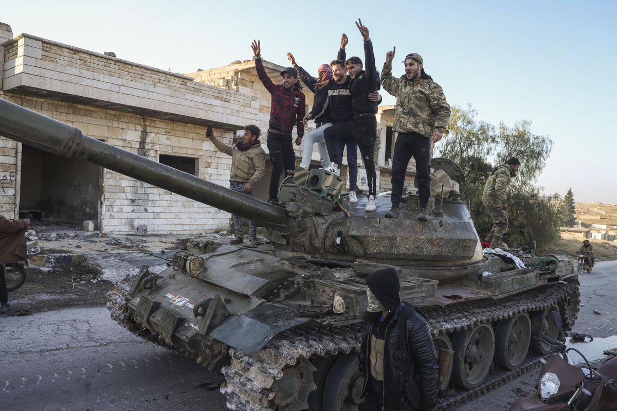 Supporters de l'opposition syrienne se tenant sur un tank capturé dans la ville de Maarat al-Numan, au sud-ouest d'Alep, Syrie, le 30 novembre 2024.