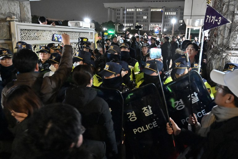 Police stand guard in front of the main gate of the National Assembly in Seoul on December 3, 2024, after South Korea's President Yoon Suk Yeol declared emergency martial law.