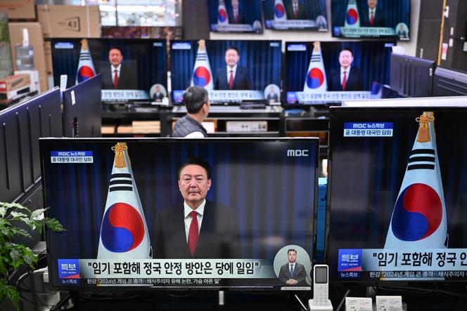 Des écrans de télévision montrent le discours en direct du président de la Corée du Sud, Yoon Suk Yeol, dans un magasin à Séoul, le 7 décembre 2024.