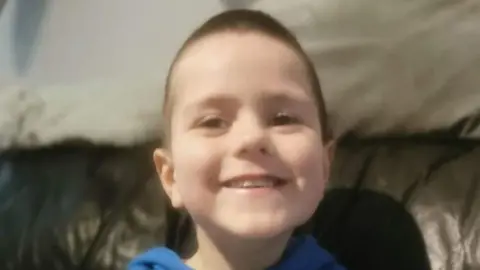 Kyran Durnin souriant, regardant directement l'objectif.
