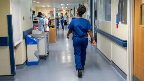 Personnel hospitalier portant des masques médicaux dans un couloir d'hôpital