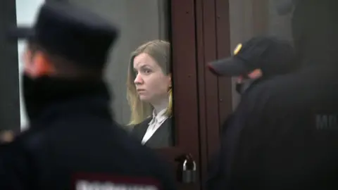 Darya Trepova dans une salle d'audience à Saint-Pétersbourg, entourée de policiers russes.