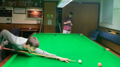 Deux jeunes hommes jouant au billard