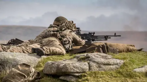Soldats tirant avec une mitrailleuse lors d'un exercice d'entraînement en 2017 au camp d'Okehampton, Dartmoor.