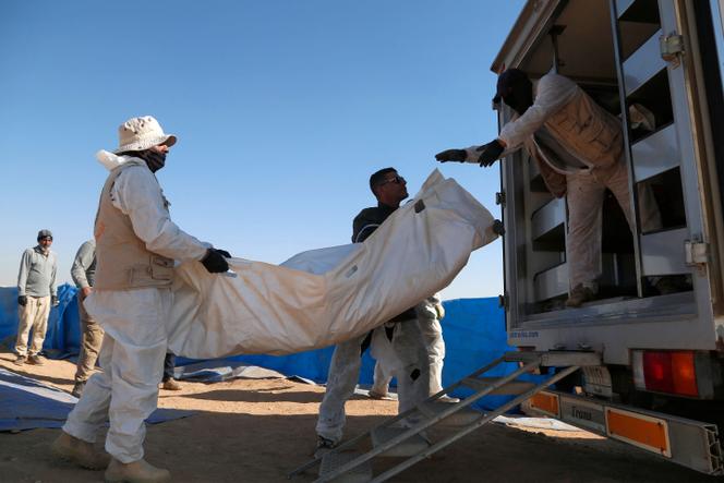 Des experts médico-légaux chargent dans un véhicule des restes humains exhumés d’une fosse commune à Tal al-Shaikhia, dans la province de Muthanna, dans le sud de l’Irak, le 25 décembre 2024.