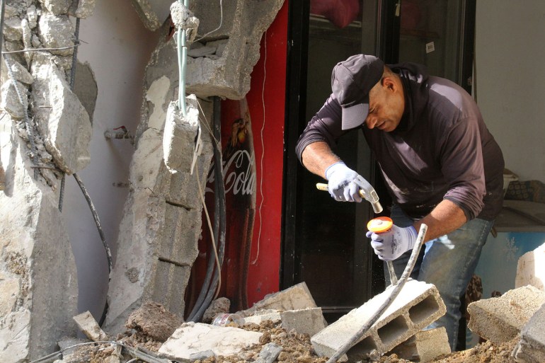 Bassem Oufi tente de réparer l'entrée de son magasin