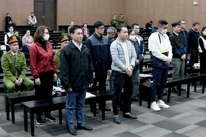 Des fonctionnaires vietnamiens accusés de corruption sur les vols de rapatriement au début de la pandémie de Covid-19 se tiennent debout lors de leur procès au tribunal populaire de Hanoï, le 24 décembre 2024.