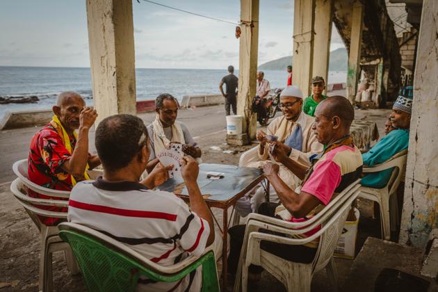 Des hommes jouent aux cartes le long du rivage à Mutsamudu, aux Comores, le 27 décembre 2024.