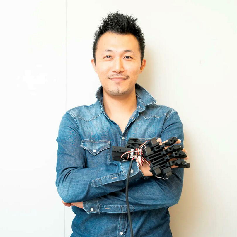 Shinichi Furuya est l'auteur principal de l'étude publiée sur l'exosquelette de main robotisé, qu'il porte sur la photo. © NeuroPiano Institute