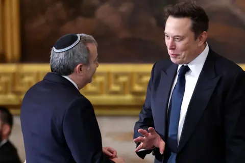 Elon Musk parlant à un homme