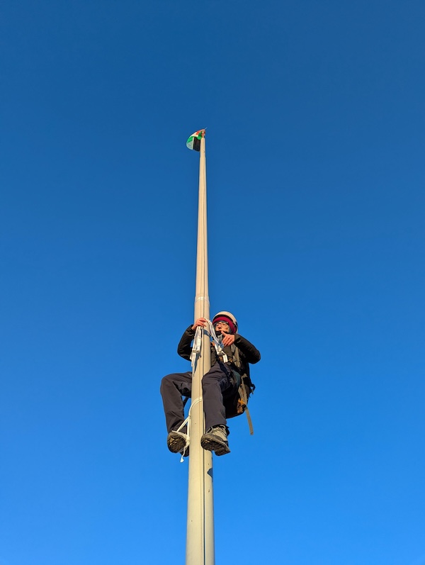 Une activiste remplace le drapeau de Leonardo par celui de la Palestine lors d'une action de protestation à Brescia, 13 janvier 2025 (Ansa)