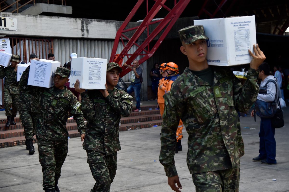 Des soldats de l’armée distribuent des dons aux personnes déplacées par des affrontements entre groupes armés, au stade General Santander à Cucuta, Colombie, le 23 janvier 2025.