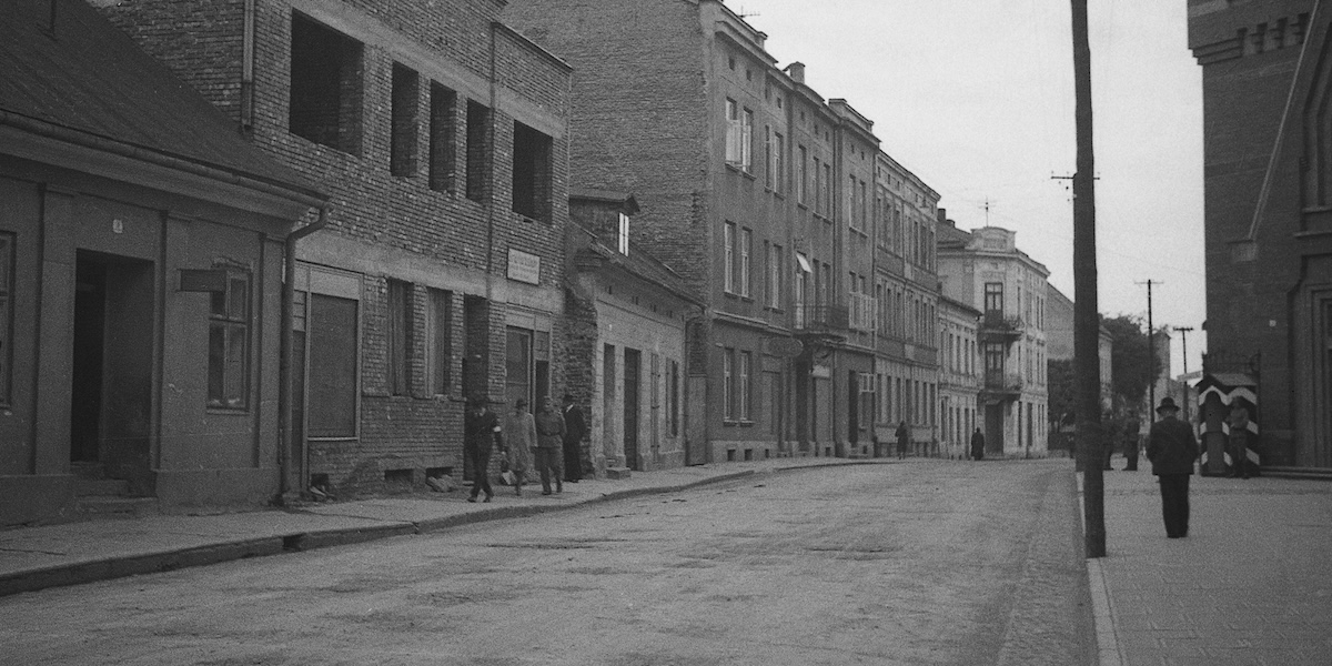 Une rue semi-déserte, avec peu de personnes marchant sur le trottoir