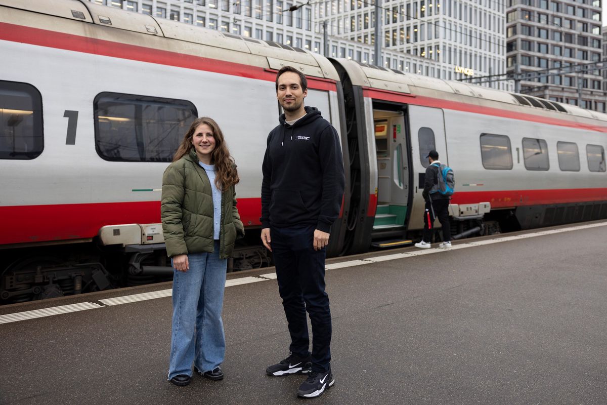 Saskia Bilang et Austin Widmer de Simple Train devant un train à grande vitesse.