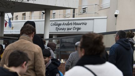 Des parents d'élèves devant le collège où était scolarisée Louise, à Epinay-sur-Orge (Essonne), le 12 février 2025. (MAGALI COHEN / HANS LUCAS / AFP)