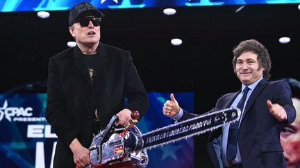 Elon Musk et la tronçonneuse offerte par Javier Milei lors de la réunion des conservateurs (CPAC) à Oxon Hill, Etats-Unis) le 20 février 2025