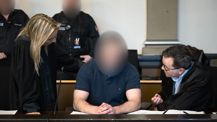 Le soldat accusé entre ses avocats.