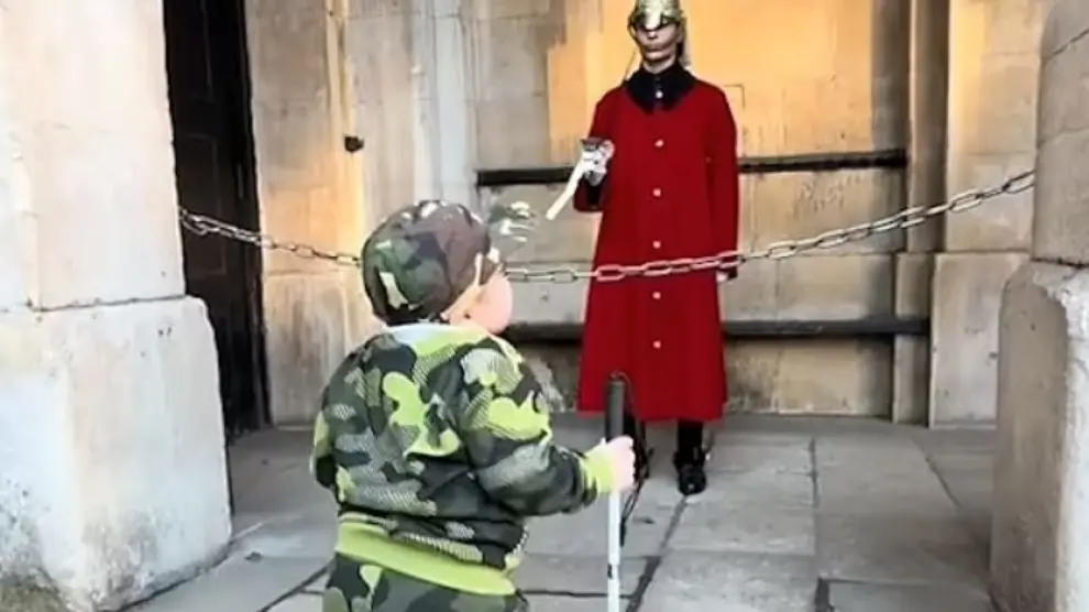 Un garde royal britannique saluant un enfant invident.