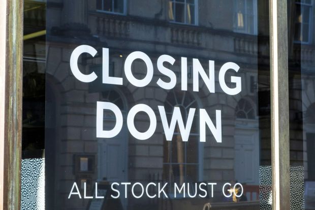 Vitrine de magasin avec l'inscription 'FERMETURE, TOUT LE STOCK DOIT PARTIR'
