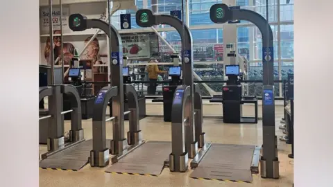 Balances géantes devant les caisses Tesco Scan as you Shop