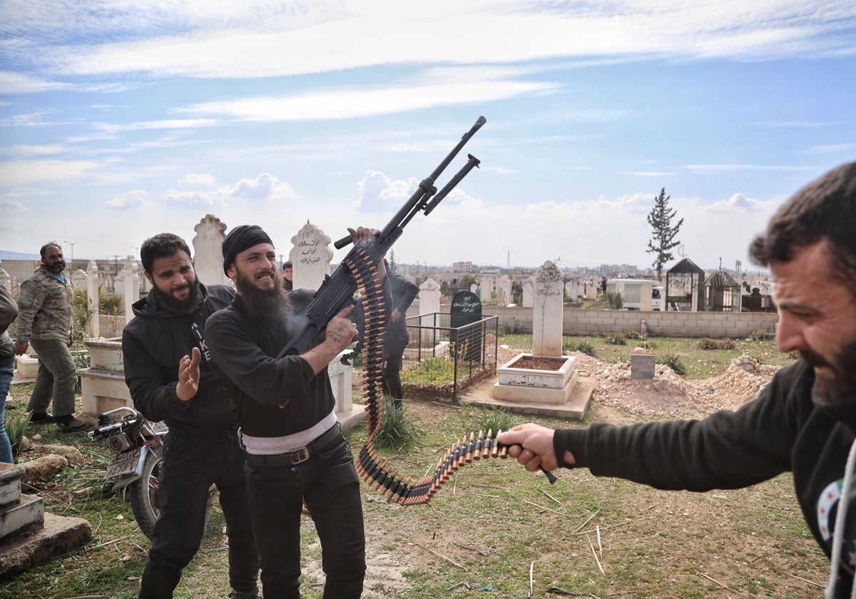 Un homme armé tire en l'air lors des funérailles d'un membre des forces de sécurité syriennes tué dans une attaque.