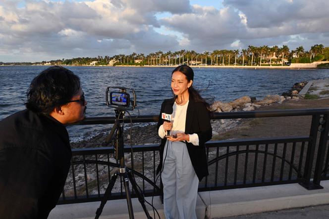 Une équipe de Voice of America lors d’un reportage sur la chaussée menant à la propriété du président élu, Donald Trump, à Mar-a-Lago, en Floride, le 13 décembre 2024.