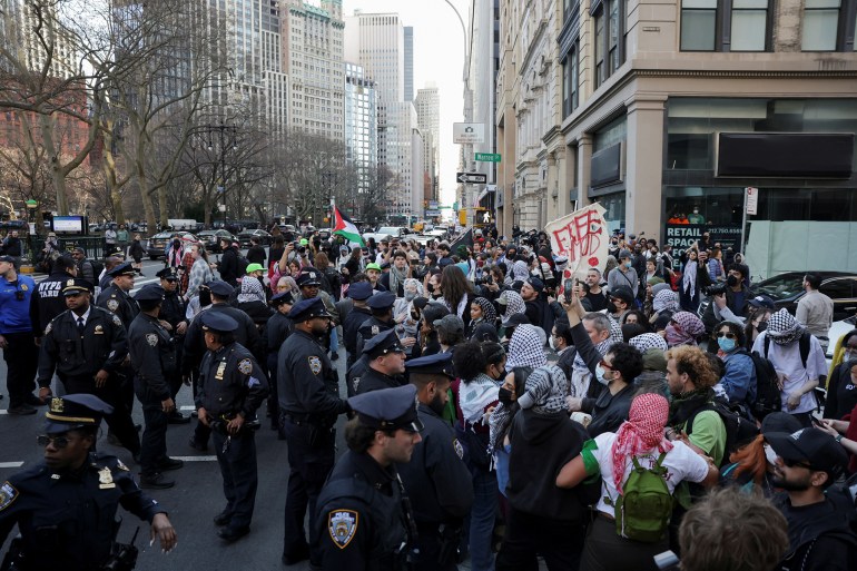 Des policiers gardent l'entrée pendant que des manifestants assistent à une protestation près de la mairie, suite à l'arrestation de l'étudiant palestinien Mahmoud Khalil à New York.