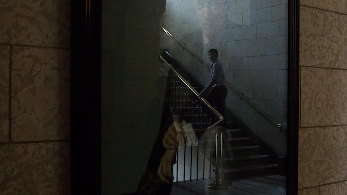 Justin Trudeau, montant un escalier dans le reflet du portrait de son père, sur la colline du Parlement à Ottawa.
