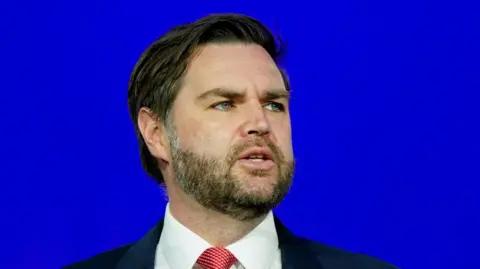 JD Vance en costume sombre avec une cravate rouge