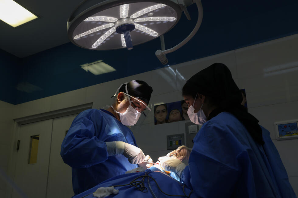 Le chirurgien iranien Hamidreza Hosnani effectue une opération du nez dans sa clinique privée de Téhéran, le 4 mars 2025.
