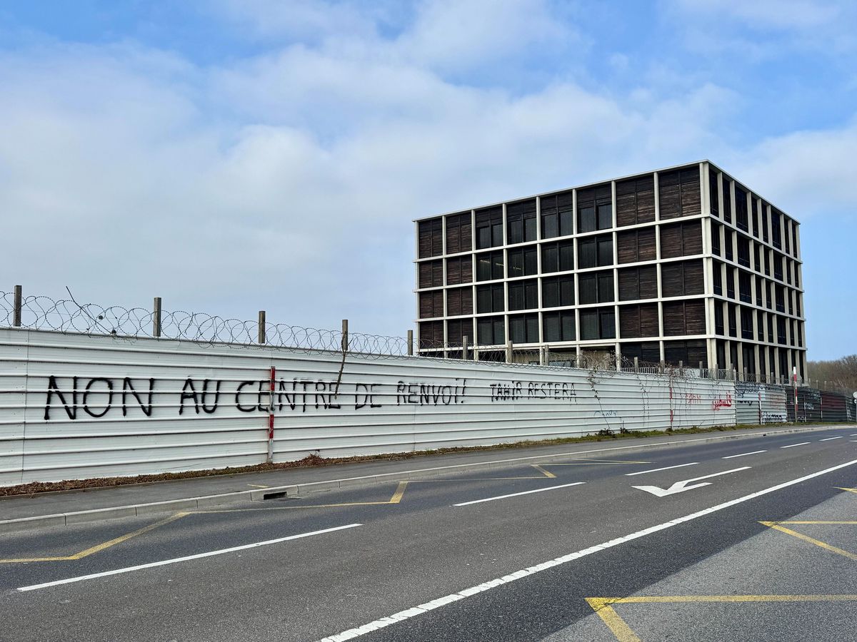 Bâtiment moderne en arrière-plan avec une clôture en tôle ondulée