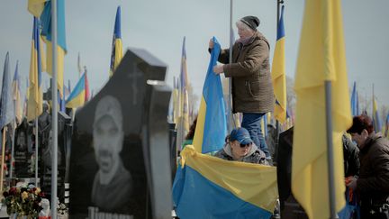 Des proches de défunts s'occupent des tombes des soldats tombés de l'Ukraine dans le cadre d'une campagne à l'échelle de la ville pour nettoyer les tombes militaires à Kharkiv, le 12 avril 2025. (IVAN SAMOILOV / AFP)