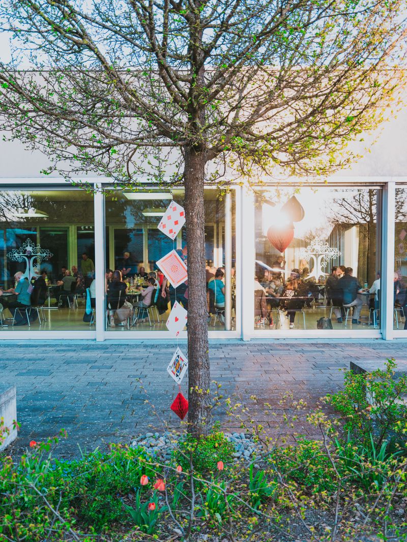 Arbre décoré de cartes à jouer devant un café