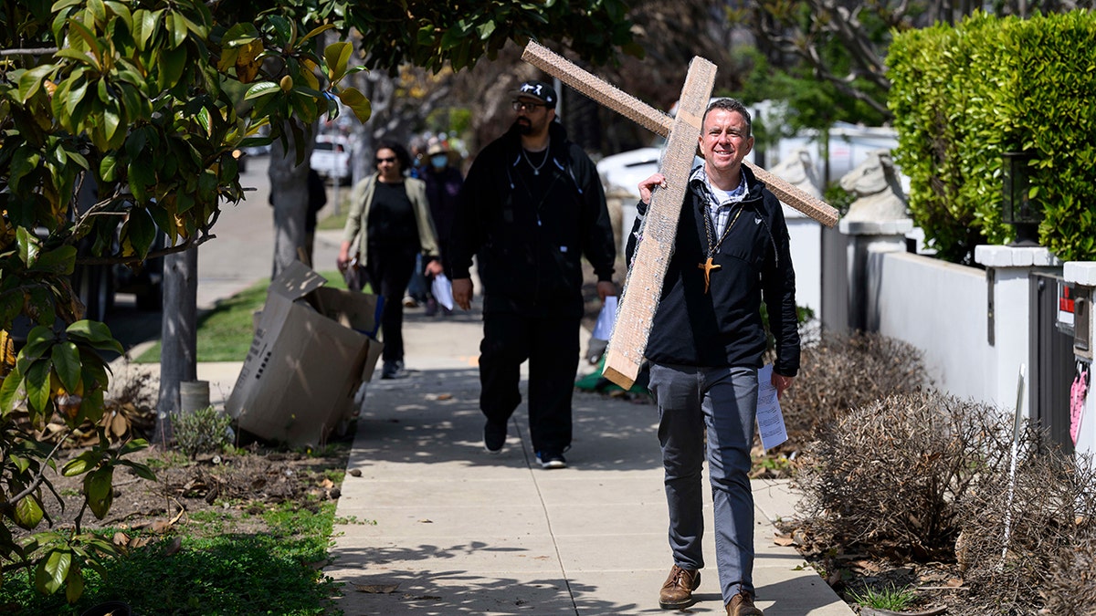 Le pasteur John Shaver porte une croix lors de la procession à Pacific Palisades