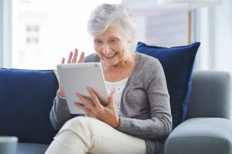 Une personne âgée fait une visio sur sa tablette