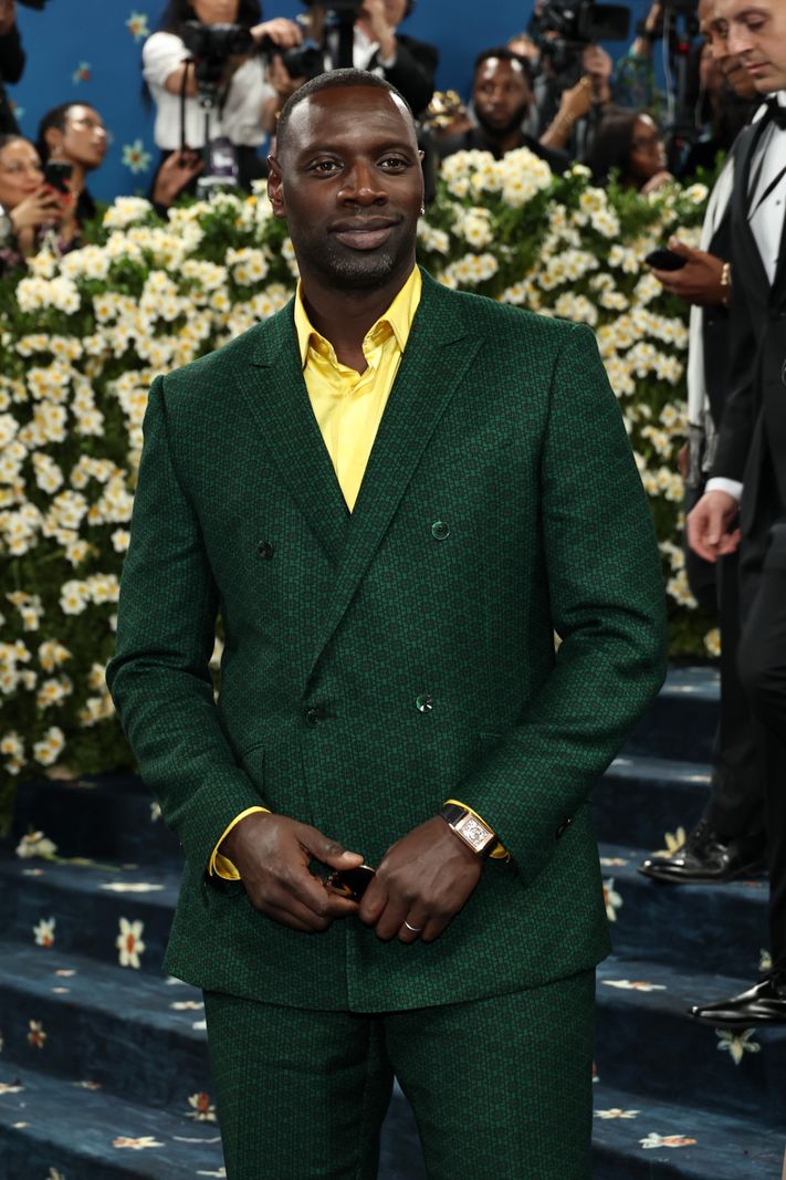 Omar Sy vêtu d’un costume vert avec chemise jaune au Met Gala 2025, célébrant ’Superfine: Tailoring Black Style’ à New York.