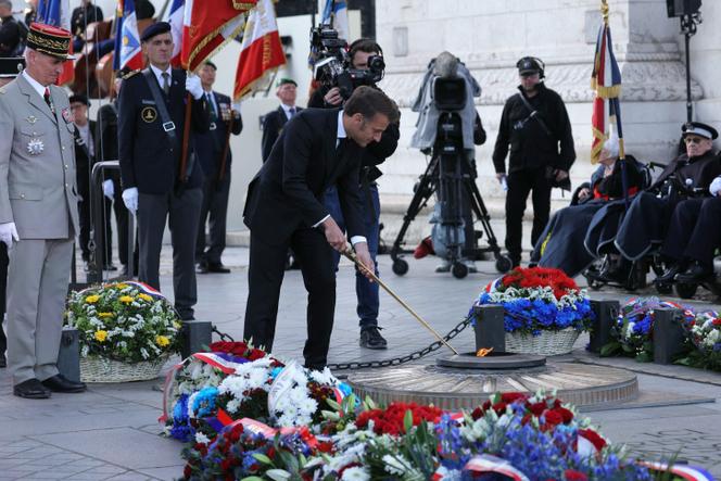 Emmanuel Macron rallume la flamme de la tombe du soldat inconnu lors d’une cérémonie à l’Arc de triomphe marquant le 80ᵉ anniversaire de la fin de la seconde guerre mondiale en Europe, à Paris, le 8 mai 2025.