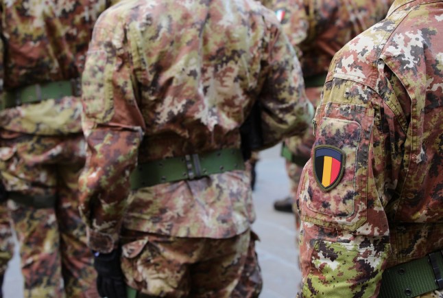 Soldat de l'armée belge en uniforme camouflé vert et marron avec l'écusson de la Belgique
