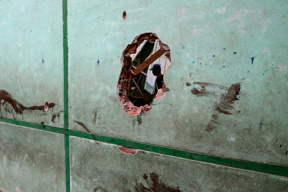 Un trou dans un mur d'un bâtiment scolaire endommagé par un bombardement à Ohe Htein, Birmanie