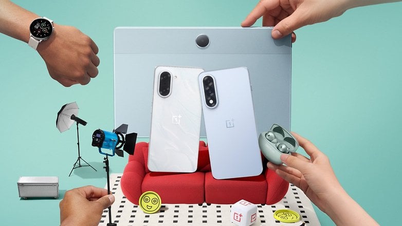 Une montre OnePlus 3 au poignet, entourée d'un téléphone, d'écouteurs et d'équipement photographique.